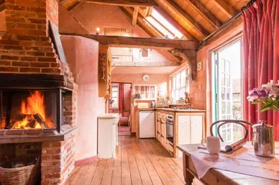a kitchen with a brick fireplace in a house at Rose Cottage rural cosiness with footpaths to the local Macro Brewery Pub in Edwardstone