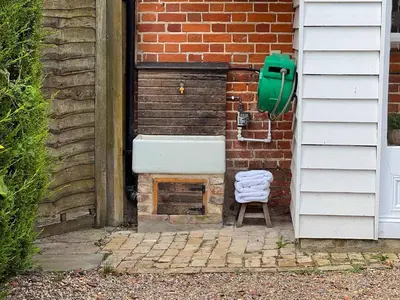 a sink and a chair next to a brick wall at Snow Cottage laid back style with footpaths to a great Macro Brewery Pub in Edwardstone