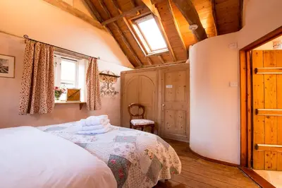 a bedroom with a bed and a wooden ceiling at Snow Cottage laid back style with footpaths to a great Macro Brewery Pub in Edwardstone