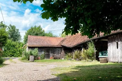 an old stone house with a roof on a yard at Dons Barn a Stunning cottage just a walk across the fields to a great pub in Edwardstone
