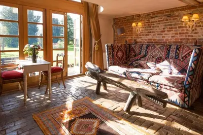 a living room with a couch and a brick wall at Dons Barn a Stunning cottage just a walk across the fields to a great pub in Edwardstone