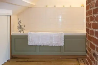 a bathroom with a sink and a bath tub at Wren Cottage, a very cosy historic Coastal Cottage in a pretty little village in Wickham Market