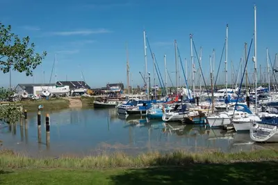a bunch of boats are docked in a marina at The Wobbin, Remote, Comfort, Sea Views and the beautiful Essex Marshes in West Mersea