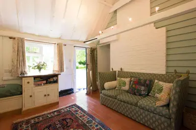 a living room with a couch and a window at The Wobbin, Remote, Comfort, Sea Views and the beautiful Essex Marshes in West Mersea