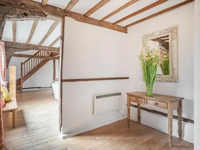 a room with a mirror and a table with flowers on it at John Fanner Barn - Uk37102 in Mellis