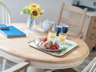 a table with a plate of croissants and fruit on it at John Fanner Barn - Uk37102 in Mellis