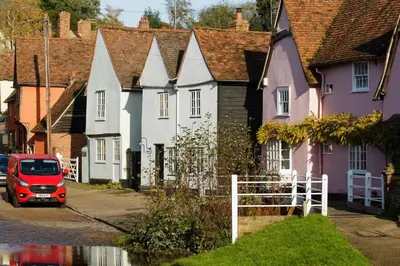 a red van parked in front of a row of houses at Water Cottage, a perfect ancient House in Suffolks prettiest tiny village in Kersey