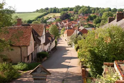 an empty street in a small village with houses at Water Cottage, a perfect ancient House in Suffolks prettiest tiny village in Kersey