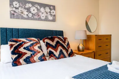 a bedroom with a bed with two pillows on it at Charming & Spacious 3BR With Private Parking Near Ipswich in Ipswich