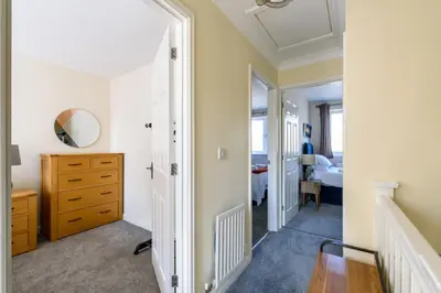 a bedroom with a dresser and a mirror at Charming & Spacious 3BR With Private Parking Near Ipswich in Ipswich