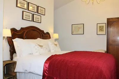 a bedroom with a large bed with a red blanket at The Compasses in Chelmsford