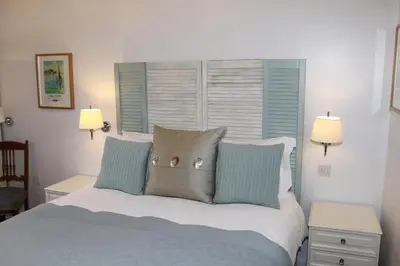 a bedroom with a bed with pillows and a window at The Compasses in Chelmsford