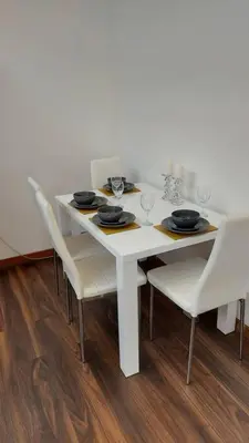 a white table with white chairs and a white table with glasses at Modern and spacious two bedroom apartment in Ipswich