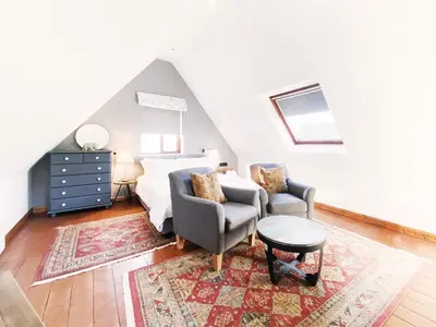 a bedroom with a bed and a couch and a chair at Little Dene Lodge by The Suffolk Cottage Collection in Pakenham