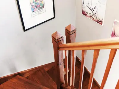 a stairway with wooden railings and pictures on the wall at Little Dene Lodge by The Suffolk Cottage Collection in Pakenham