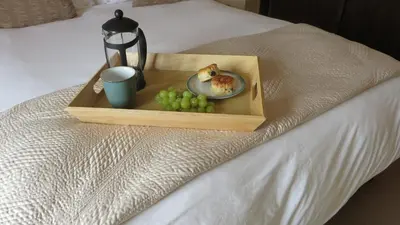 a tray with a plate of food on a bed at Citystay Living- Warren Close in Cambridge