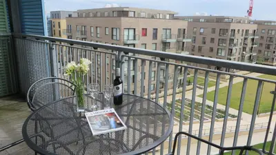 a glass table with a bottle of wine on a balcony at Citystay Living- Warren Close in Cambridge
