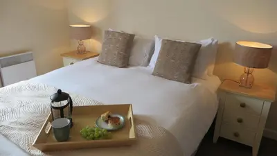 a white bed with a tray of grapes on it at Citystay Living- Warren Close in Cambridge