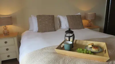 a tray of food and a plate of grapes on a bed at Citystay Living- Warren Close in Cambridge