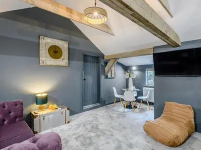 a living room with a purple couch and a table at 1 Lamb Barn in Clacton-on-Sea