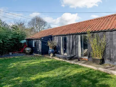 a house with a garden and a yard with a house at 1 Lamb Barn in Clacton-on-Sea