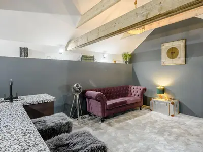 a living room with a couch and a camera at 1 Lamb Barn in Clacton-on-Sea