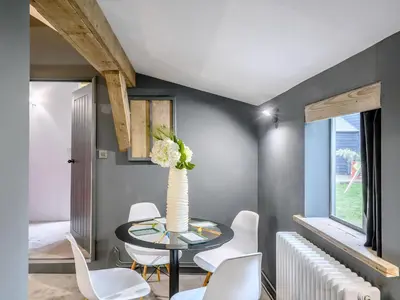a dining room with a table and white chairs at 1 Lamb Barn in Clacton-on-Sea