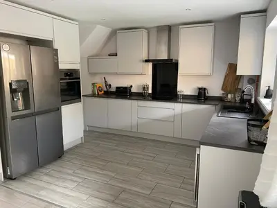 a kitchen with white cabinets and stainless steel appliances at •11 The Nook in Wivenhoe