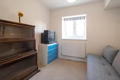 a living room with a couch and a television at Gun Lodge - Aldeburgh Coastal Cottages in Aldeburgh