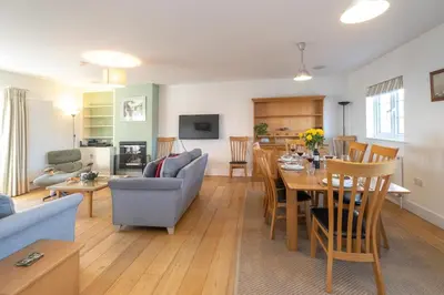 a living room and dining room with a table and chairs at Gun Lodge - Aldeburgh Coastal Cottages in Aldeburgh