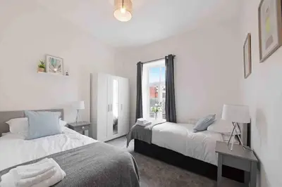 a bedroom with two beds and a window at Town center apartment in Bishops Stortford in Birchanger
