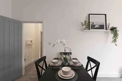 a dining room with a black table and chairs at Town center apartment in Bishops Stortford in Birchanger
