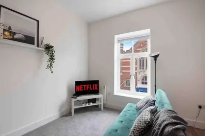 a living room with a couch and a window at Town center apartment in Bishops Stortford in Birchanger