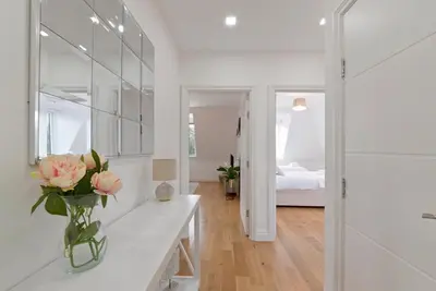 a white room with a vase of flowers on a counter at Spacious Two Bed loft Apartment in Birchanger