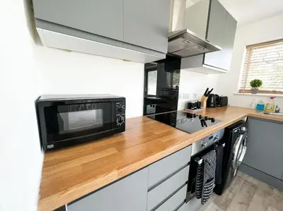 a kitchen with a wooden counter top with a microwave at Starview Apartment - Hawthorne in Colchester
