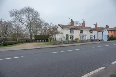 a white house on the side of a street at 2 Riverside Cottages, Yoxford in Saxmundham
