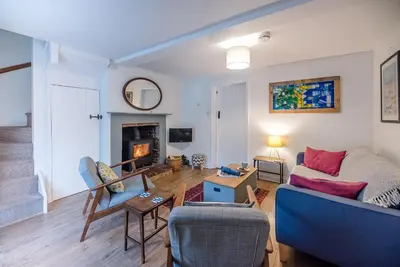 a living room with a couch and a fireplace at 2 Riverside Cottages, Yoxford in Saxmundham