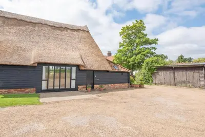 a thatch roofed house with a driveway at Harvest Cottage, Valley Farm, Snape in Saxmundham