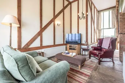a living room with two couches and a tv at Harvest Cottage, Valley Farm, Snape in Saxmundham