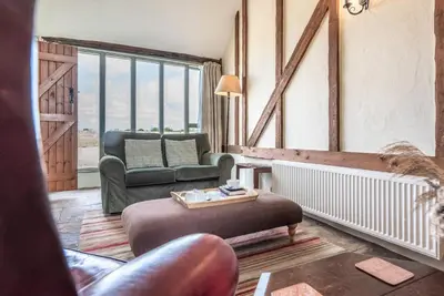 a living room with a couch and a chair at Harvest Cottage, Valley Farm, Snape in Saxmundham