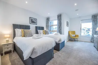 a bedroom with two beds and a window at 2 Deben Wharf, Woodbridge in Woodbridge