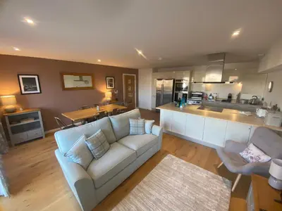 a living room with a couch and a kitchen at 2 Deben Wharf, Woodbridge in Woodbridge