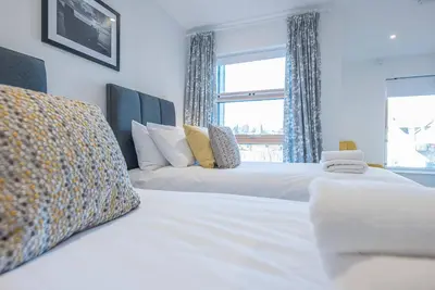 two beds in a bedroom with a window at 2 Deben Wharf, Woodbridge in Woodbridge