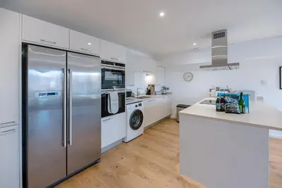 a kitchen with stainless steel appliances and white cabinets at 2 Deben Wharf, Woodbridge in Woodbridge