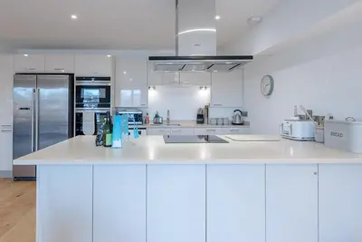 a kitchen with white cabinets and a white counter top at 2 Deben Wharf, Woodbridge in Woodbridge