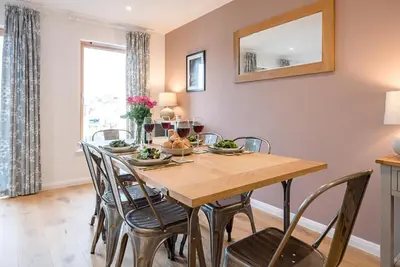 a dining room with a wooden table and chairs at 2 Deben Wharf, Woodbridge in Woodbridge