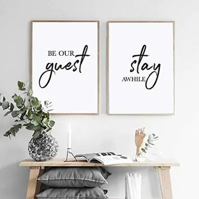 three posters on a wall with a table with a book at Stansted Airport Guest Rooms in Bishops Stortford