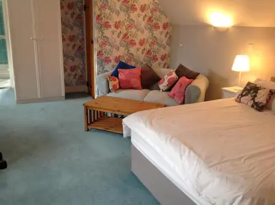a living room with a bed and a couch at Dragonfly Cottage, Rattlesden in Rattlesden
