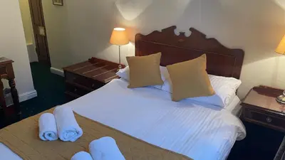 a hotel room with a bed with towels on it at Crown Hotel in Downham Market