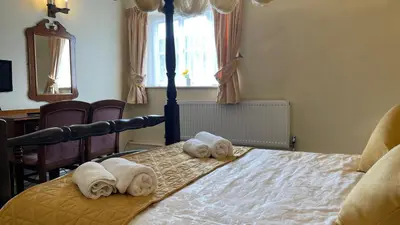 a bedroom with a bed with towels on it at Crown Hotel in Downham Market